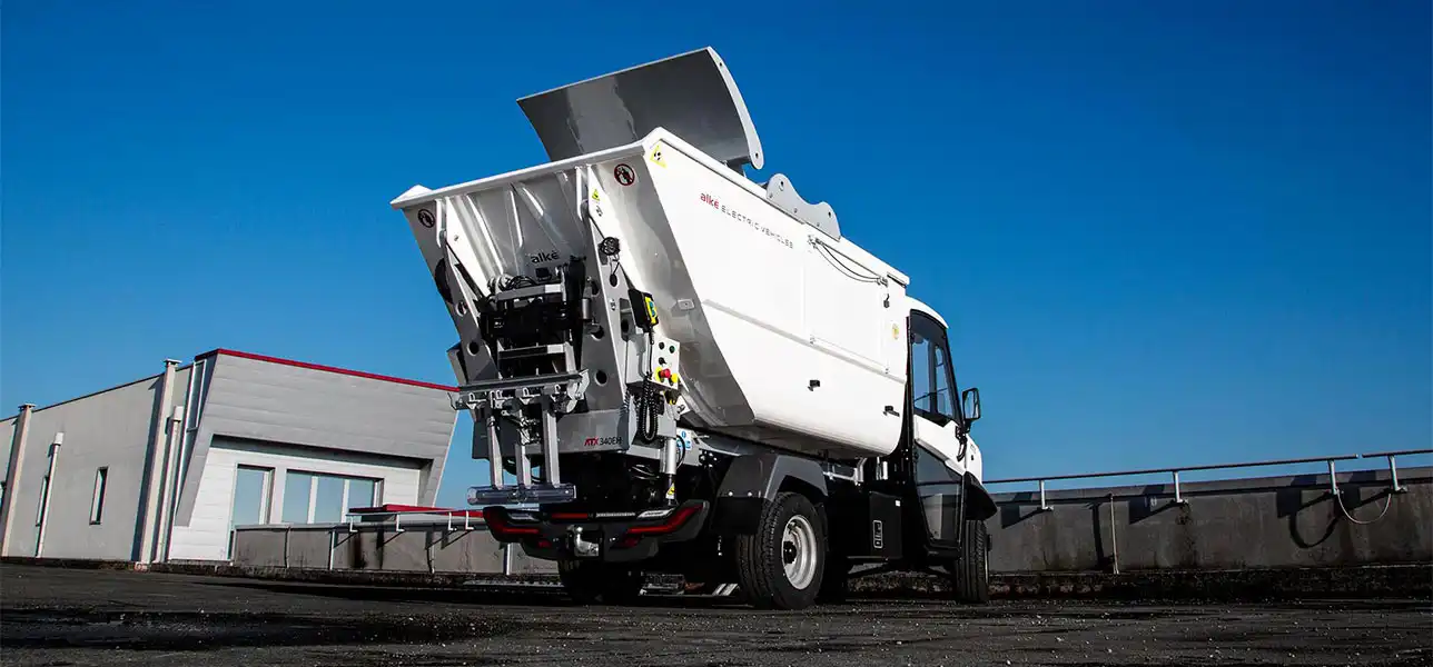 Electric vehicle with waste collection tank and rammer